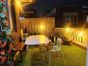a white table and chairs on a balcony at night at Urban in Suwon