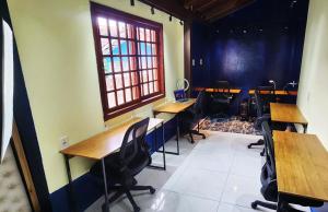 a room with desks and chairs in a room with a window at Casa Maré Floripa - Coliving, Coworking and Community in Florianópolis