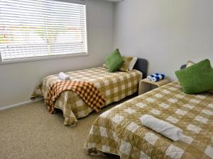 a bedroom with two beds and a window at Beachfront Bliss in Lennox Head
