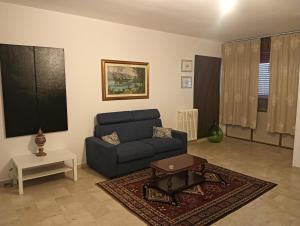 a living room with a blue couch and a table at Dimora De' Luna in Lecce
