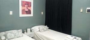 Un dormitorio con dos camas y un cuadro en la pared. en GR Hotel, en La Rioja