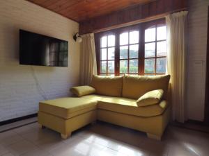 a living room with a yellow couch and a window at casa dúplex a 50 metros del mar in Ostende