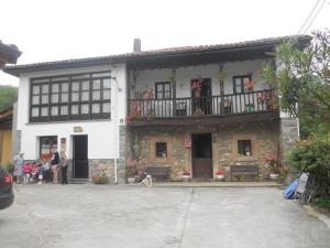 Um edifício com um cão à frente. em El Molin De Frieras em Posada de Llanes