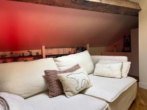 een witte bank met kussens op de kamer bij Nid douillet sous les toits bourguignons in Dijon