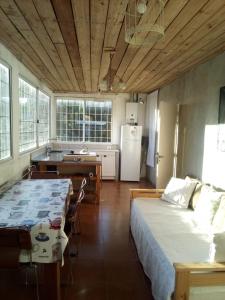 Un dormitorio con una cama grande y una cocina. en Luli 1, en Villa Gesell