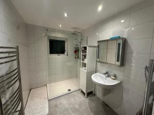 a white bathroom with a sink and a shower at Randall Farm in Fawkham