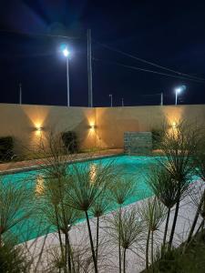 una piscina iluminada por la noche con luces en Esmeralda, en San Benito