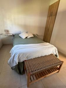 a bedroom with a bed with a bench next to it at Esmeralda in San Benito +5 photos