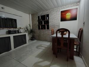 cocina con mesa, TV, mesa y sillas en Hospedaje SKYHOME II, en Nu Guazu 7 fotos más