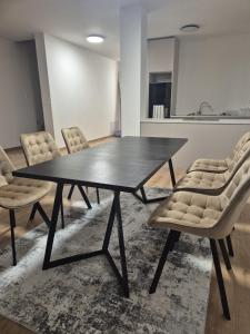 Un comedor con una mesa y sillas negras. en Rezidencia pri Kaštieli 5, en Sokoľany