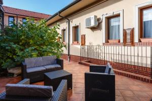 a patio with a couch and chairs on a house at Old Town Treasure Apartments in Debrecen +2 photos