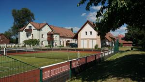 una pista de tenis frente a una casa en Penzion Nad Oborou, en Hradec Králové