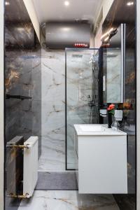 a bathroom with a white sink and a marble wall at Old Town Treasure Apartments in Debrecen