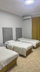 a group of beds in a room at فندق فؤاد علي العذي للشقق المخدومه in Taif