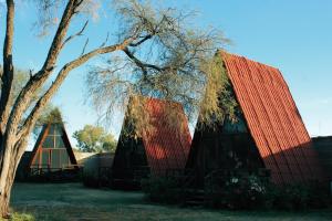a house with a red roof and a tree at Cabañas Hacienda de Letras in Pabellón de Arteaga