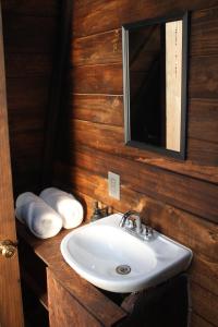 a bathroom with a sink and a mirror and towels at Cabañas Hacienda de Letras in Pabellón de Arteaga