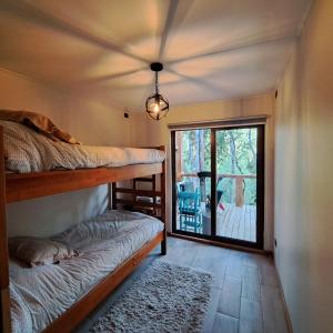 Zimmer mit 2 Etagenbetten und einer Glasschiebetür in der Unterkunft Refugio en Los Arrayanes in Valdivia
