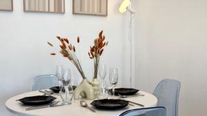 a white table with a vase with flowers on it at Vue imprenable sur mer in Tangier