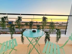 a table and two chairs on a balcony with plants at Vue imprenable sur mer in Tangier