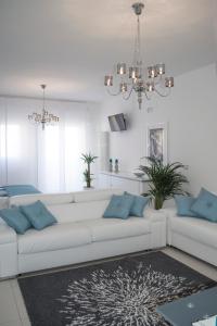 a white living room with a white couch and blue pillows at Artist's suite in Bari