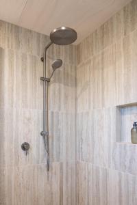 a shower with a shower head in a bathroom at Purangi Views in Cooks Beach +57 photos