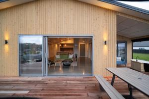 a house with sliding glass doors on a deck at Purangi Views in Cooks Beach
