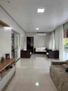 een grote woonkamer met een bank en een tafel bij Refúgio na natureza in Parauapebas