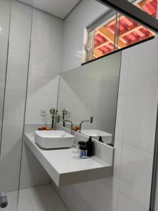 een witte badkamer met een wastafel en een raam bij Refúgio na natureza in Parauapebas +34 foto's