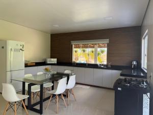 een keuken met een tafel en witte stoelen. bij Refúgio na natureza in Parauapebas