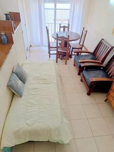 a bedroom with a bed and a table and chairs at Depto Avenida Colón-Mar del Plata in Mar del Plata +2 photos