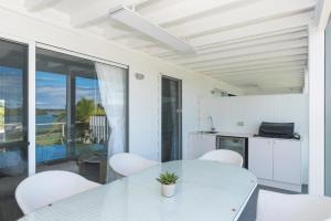 Unit 8 8- 10 Electra Parade Harrington في Manning Point: مطبخ وغرفة طعام مع طاولة وكراسي