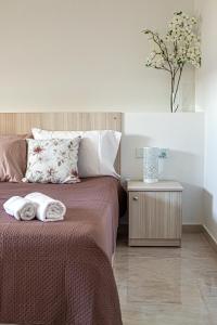 Un dormitorio con una cama con toallas. en Birzebbuga Sunset, en Birżebbuġa