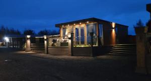 een klein huis met 's nachts verlichting bij Mary Queen of Scott's Lodge in Carberry