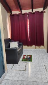 ein Wohnzimmer mit einem Sofa und einem roten Vorhang in der Unterkunft Habitación en Residencia Familiar in Asunción