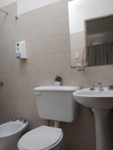 Un baño blanco con inodoro y lavabo. en GR Hotel, en La Rioja