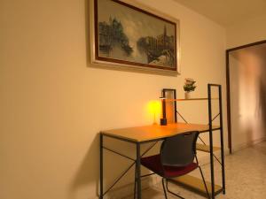 una scrivania e una sedia in una stanza con un dipinto di Renta de habitación desde 1 noche baño privado a Saltillo