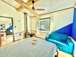 Cette chambre comprend un lit bleu et un canapé bleu. dans l'établissement Sea Roots "Garden Zone ", à Mosteiros