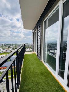 a balcony with green grass and large windows at Departamento 2 dormitorios vista al lago in Villarrica