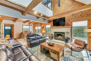 a living room with leather furniture and a fireplace at 8 Mi to Mt Snow Cozy Bear Cabin with Hot Tub! in Wilmington