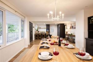 una sala da pranzo con un lungo tavolo e bicchieri da vino di The Meadow Yarra Valley Large Entertainer with Spa & Sauna a Yarra Glen
