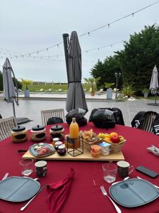 OyréKourline Villalunoterie Futuroscope Piscine spa的一张桌子,上面有红色的桌布,上面有食物