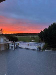 OyréKourline Villalunoterie Futuroscope Piscine spa的从房子的屋顶上欣赏日落美景