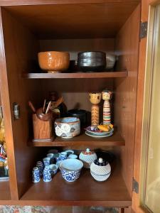 une armoire remplie de nombreux plats et bols dans l'établissement 民宿とまとハウスTomato House, à Funehiki