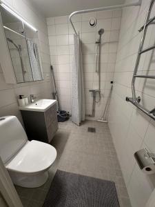 a white bathroom with a toilet and a sink at Noah Longstay Bygatan in Västerås