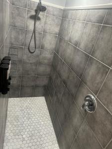 a shower with a shower head in a bathroom at Peaceful 4BR Haven in Stn Mtn GA in Stone Mountain +19 photos