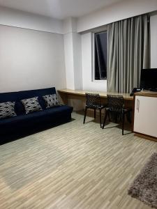 een woonkamer met een bank en een tafel bij Flat no hotel Comfort em Alphaville in Barueri