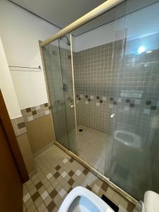 een badkamer met toilet en glazen douche bij Flat no hotel Comfort em Alphaville in Barueri