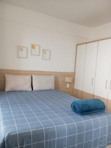 een bed met een blauw kussen erop bij Flat no hotel Comfort em Alphaville in Barueri