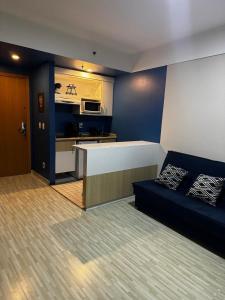 een woonkamer met een bank en een keuken bij Flat no hotel Comfort em Alphaville in Barueri