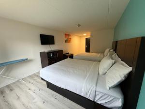a bedroom with a white bed and a television at Howard Johnson by Wyndham Brampton in Brampton